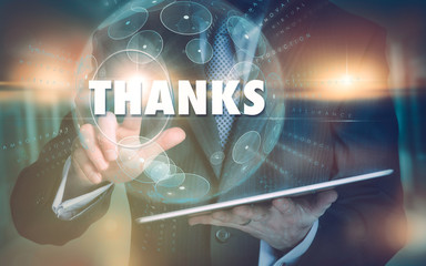 A hand selecting a Thanks business concept on a futuristic computer display.