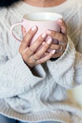 Portrait of a beautiful young woman holding a cup of hot coffee