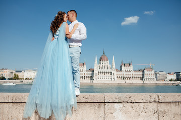 Obraz premium A loving young beautiful couple embrace against the backdrop of a beautiful view of Prague in the Czech Republic. Close feelings and emotions between people. Happy young couple in love