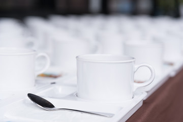 Close up white coffee cup on brown tablecloth for coffee break at conference meeting.Selective focus.