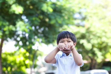 An Asian young boy playing happily and cheerfully outdoor with copy space.