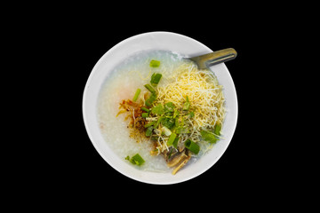 Rice congee with minced pork, boiled egg and vegetable in white ceramic bowl isolate on black background with clipping path. 