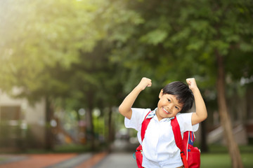 An Asian young boy with school uniform getting excited and cheerful when coming back to school.