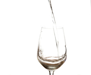 Water splashing in wine glass isolated on white