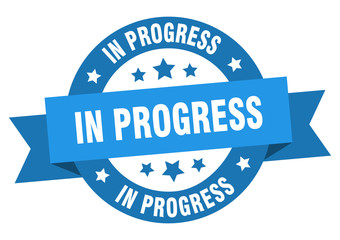 in progress ribbon. in progress round blue sign. in progress