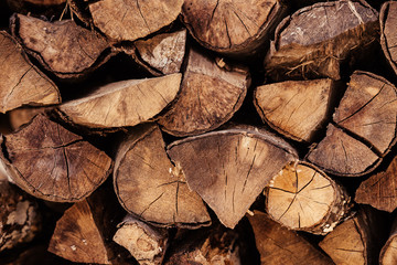 Close-up wooden logs folded in the form of woodpile lie on the street. Concept of rustic background and country life