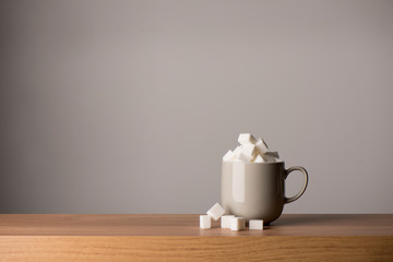 Ceramic Coffee Mug Overflowing with Sugar Cubes, Copy Space