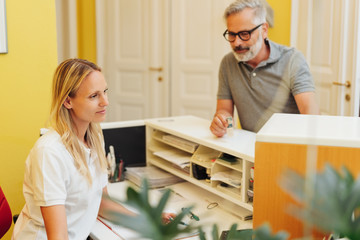 Medical receptionist attending to a male patient