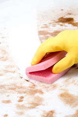 Gloved Hand Wiping Spills on Counter or Floor with Pink Sponge