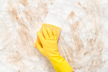 Hand Wiping Clean a Dirty Marble Counter with Sponge