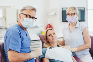 Fototapeta premium Dentist posing with his patient and nurse