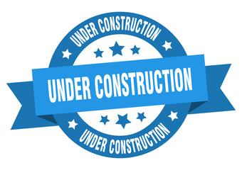 under construction ribbon. under construction round blue sign. under construction