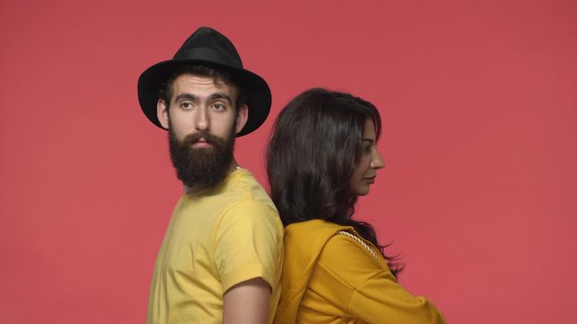 Boyfriend made girlfriend sulk, standing back to back, middle-eastern guy turn behind trying apologize indian woman, feeling guilty and upset, girl act offended and moody, red background