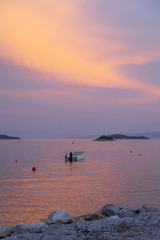 A sunset with a boat centre frame