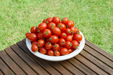 Pile of juicy fresh cherry tomatoes in a white dish