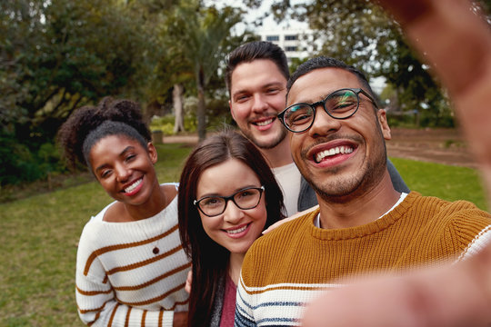 Multi ethnic people enjoying time together and taking selfie in the park