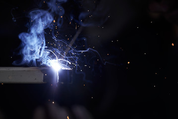 Welding works in the dark. Sparks and blue light when welding.