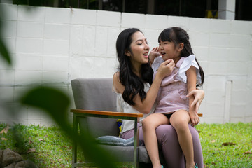 Happy asian mother and daughter relaxing together in the garden.
