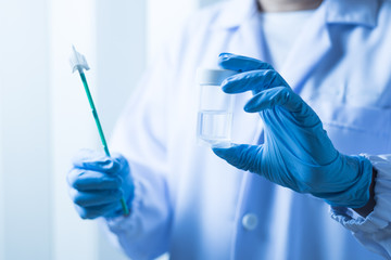 Doctor hand holding liquid base cytology set on blue background.Gynecologist working for vaginal...