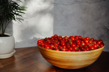  Large wooden bowl with cherry tomatoes. seasonal vegetables