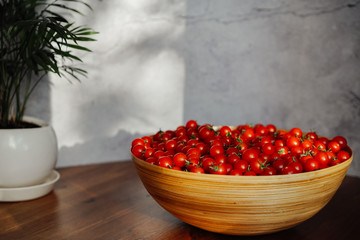  Large wooden bowl with cherry tomatoes. seasonal vegetables