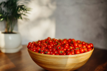  Large wooden bowl with cherry tomatoes. seasonal vegetables