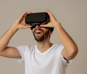 Portrait of excited and amazed young man wearing Virtual Reality headset exploring 3D world