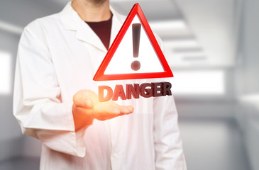 Young white scientist holding a red danger triangle warning sign on a blurred hospital background 3d rendering. Concept for overmedication, virus spreading and healthcare threats.