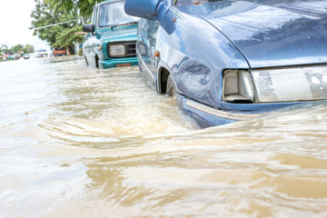 Cars driving on a flooded road, The broken car is parked in a flooded road. .