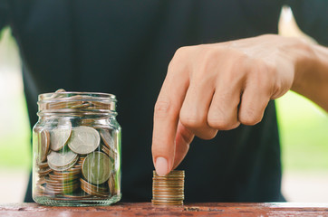 businessman putting coin stacking in to glass jar count the money for saving concept. budgeting for investment startup business.