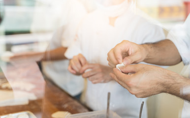 Close up hand of chef are make Xiao long bao.It is the most popular Chinese dim sum dishes. Xiao long bao is made from bread flour mixed with wheat flour with minced pork filled with broth in the wate