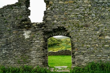 Fototapeta premium Pastoral Meadow as Seen Through a Stone Window of a Ruined Castle