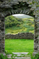 Fototapeta na wymiar Pastoral Meadow as Seen Through a Stone Window of a Ruined Castle