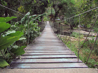 Obraz premium Old wooden suspension bridge over river water in Baturite, Ceara