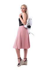 Side view of stylish urban vogue blonde woman with glasses and trendy bag looking at camera. Full body isolated on white background.