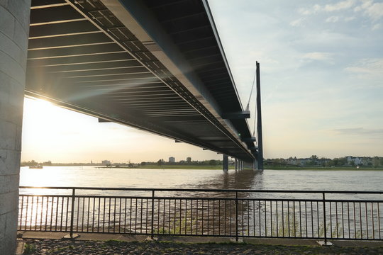 Sunset light coming from underneath the bridge over a river, Dusseldorf Germany, Rhine river