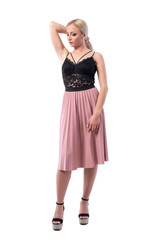 Affectionate elegant blonde beauty fashion model woman holding hair and looking down. Full body isolated on white background.