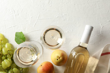 Pears, grape, bottle and glass with wine on white background, top view