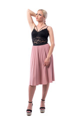 Elegant feminine gorgeous blonde fashion girl holding hair with hand looking up. Full body isolated on white background.