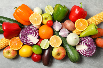 Different vegetables and fruits on grey background, top view