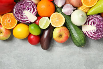 Different vegetables and fruits on grey background, top viewDifferent vegetables and fruits on grey background, top view