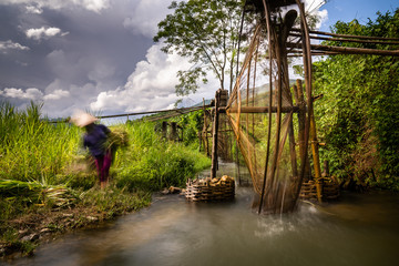 Long exposure movement. Woman working at the Pu Luong water wheels. Vietnam rural landscape in the Mai Chau area.