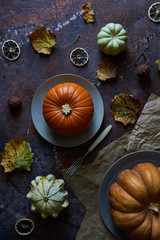 Pumpkin on a plate. Autumn cozy background with leaves, vanilla.