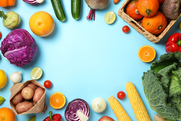 Different vegetables and fruits on blue background, copy space