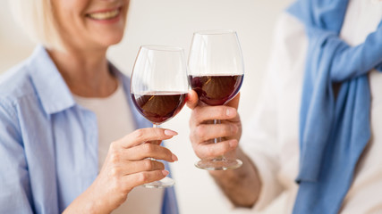 Mature couple clinking glasses of red wine