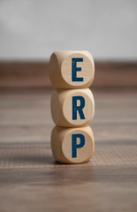 Cubes and dice with ERP Enterprise-Resource-Planning on wooden background