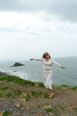Fototapeta na wymiar Red haird girl in long white skirt traveler in nature looking to beautiful view and small island in Vung Tau.Relax time on holiday concept travel .