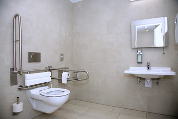 Behindertengerechte Toilette mit unterfahrbarem Waschbecken und Abstützmöglichkeiten