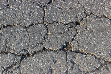 the destroyed part and the crumbling piece of asphalt, part of the poor quality road