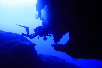 宮古島市下地島にあるダイビングスポットの海底洞窟の女王の部屋で泳ぐダイバー